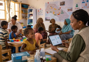 Healthcare worker reviews health data on a tablet with a child in a community clinic